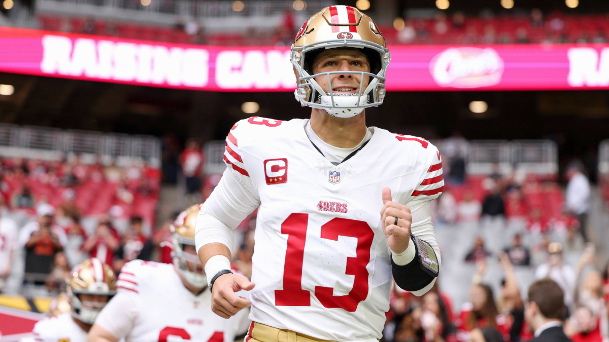 Brock Purdy #13 of the San Francisco 49ers runs onto the field for warmups before the game against the Arizona Cardinals at State Farm Stadium on November 16, 2025 in Glendale, Arizona.