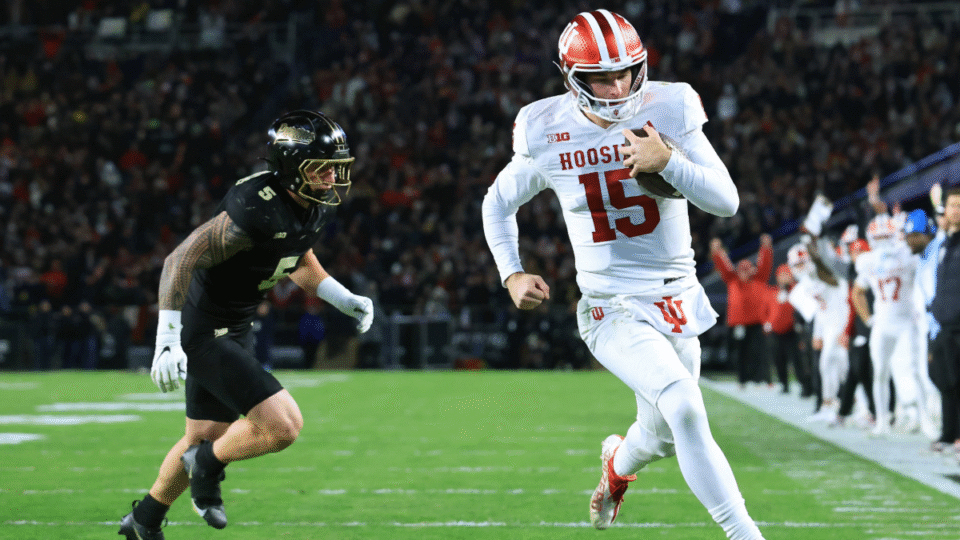 Fernando Mendoza #15 of the Indiana Hoosiers scores a touchdown while being chased by Charles Correa #5 of the Purdue Boilermakers at Ross-Ade Stadium on November 28, 2025 in West Lafayette, Indiana.