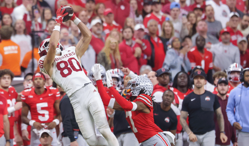 Charlie Becker #80 of the Indiana Hoosiers catches a pass against Jermaine Mathews Jr. #7 of the Ohio State Buckeyes in the 2025 Big Ten Championship game at Lucas Oil Stadium on December 6, 2025 in Indianapolis, Indiana.