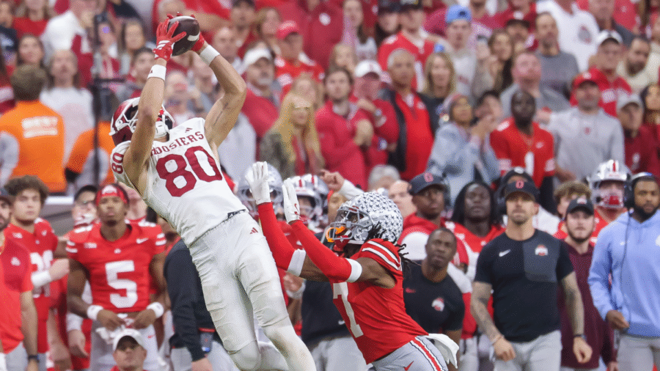 Charlie Becker #80 of the Indiana Hoosiers catches a pass against Jermaine Mathews Jr. #7 of the Ohio State Buckeyes in the 2025 Big Ten Championship game at Lucas Oil Stadium on December 6, 2025 in Indianapolis, Indiana.
