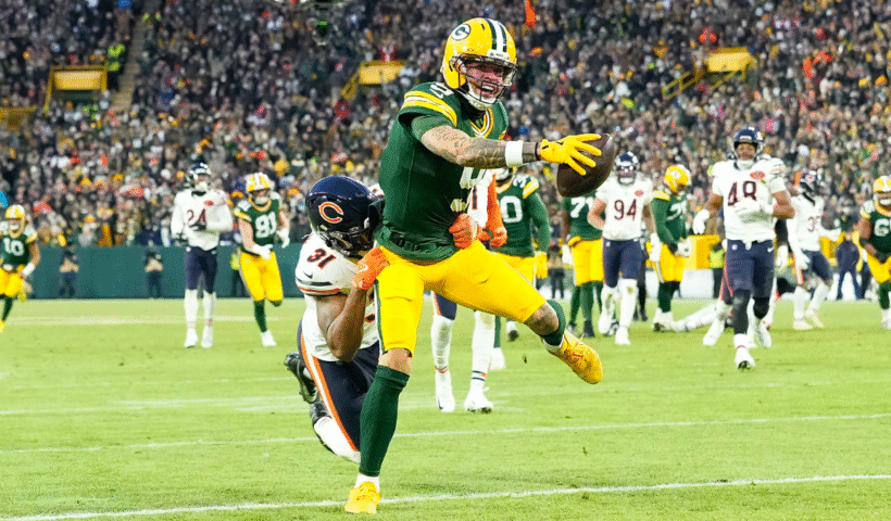 Christian Watson #9 of the Green Bay Packers reaches over the goal line for a touchdown during the game against the Chicago Bears at Lambeau Field on December 07, 2025 in Green Bay, Wisconsin.