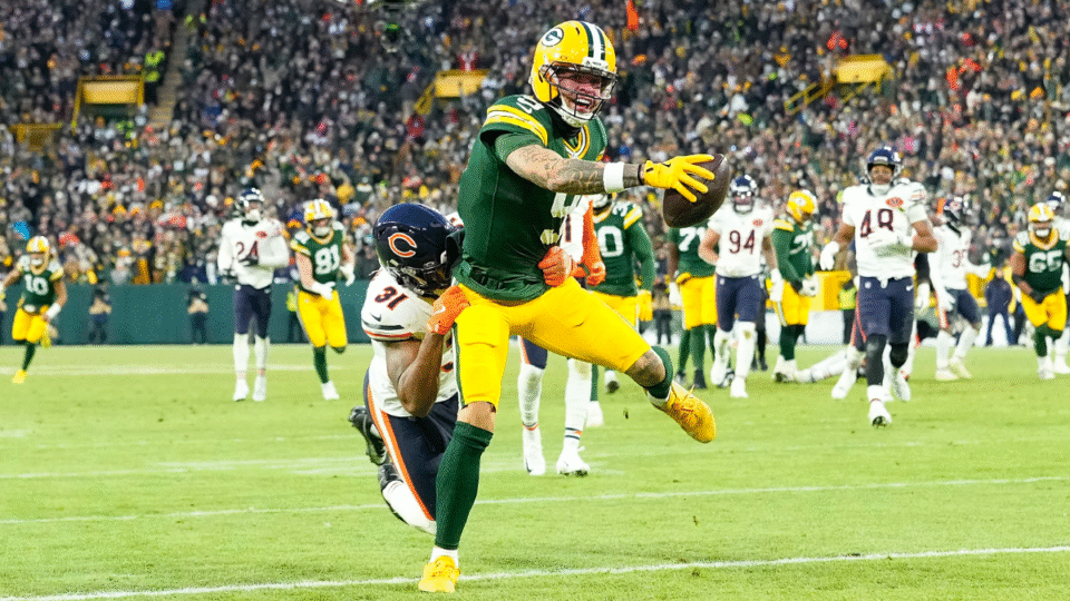 Christian Watson #9 of the Green Bay Packers reaches over the goal line for a touchdown during the game against the Chicago Bears at Lambeau Field on December 07, 2025 in Green Bay, Wisconsin.