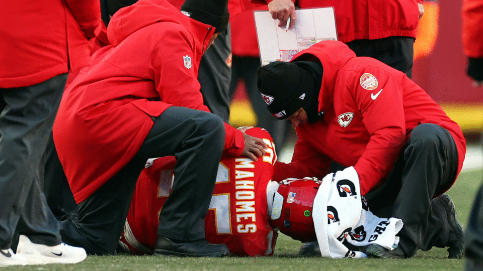 Patrick Mahomes #15 of the Kansas City Chiefs lays on the ground after sustaining an injury during the fourth quarter against the Los Angeles Chargers at Arrowhead Stadium on December 14, 2025 in Kansas City, Missouri.