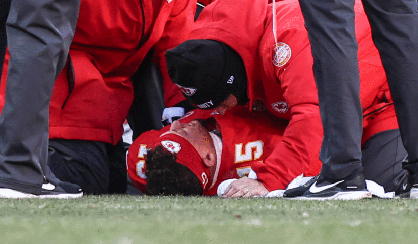 Kansas City Chiefs training staff talk with quarterback Patrick Mahomes (15) as he lies on the ground after injuring his knee in the fourth quarter of an NFL game between the Los Angeles Chargers and Kansas City Chiefs on December 14, 2025 at GEHA Field at Arrowhead Stadium in Kansas City, MO.