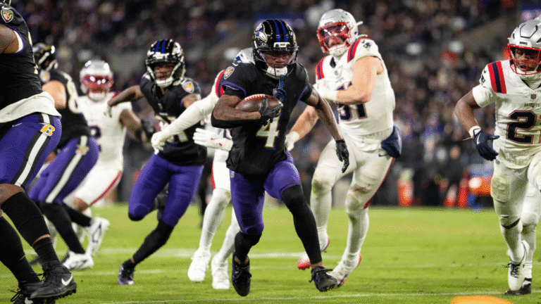 Zay Flowers #4 of the Baltimore Ravens runs with the ball and scores a touchdown during an NFL football game against the New England Patriots at M&T Bank Stadium on December 21, 2025 in Baltimore, Maryland.