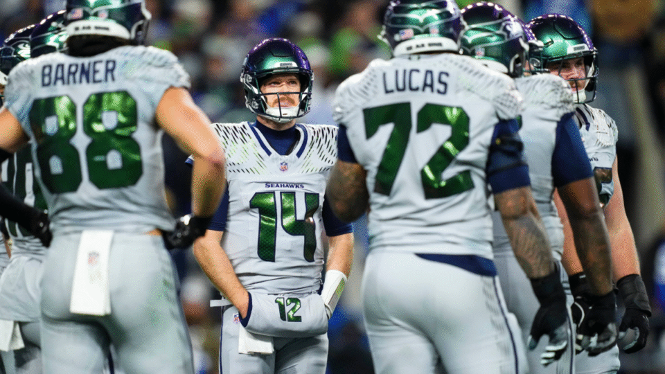 Sam Darnold #14 of the Seattle Seahawks looks on from the field during an NFL football game against the Los Angeles Rams at Lumen Field on December 18, 2025 in Seattle, Washington.