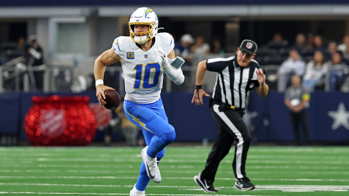 Justin Herbert #10 of the Los Angeles Chargers runs for yards during a game against the Dallas Cowboys at AT&T Stadium on December 21, 2025 in Arlington, Texas. The Chargers defeated the Cowboys 34-17.