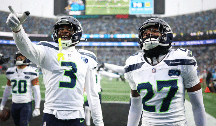 Nick Emmanwori #3 and Riq Woolen #27 react after Julian Love #20 of the Seattle Seahawks intercepted a pass during the third quarter against the Carolina Panthers at Bank of America Stadium on December 28, 2025 in Charlotte, North Carolina.