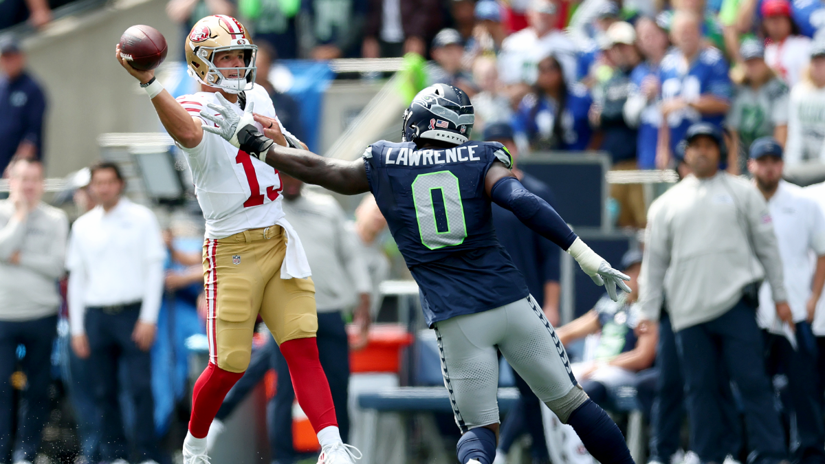 DeMarcus Lawrence #0 of the Seattle Seahawks pressures Brock Purdy #13 of the San Francisco 49ers during the NFL 2025 game between San Francisco 49ers and Seattle Seahawks at Lumen Field on September 07, 2025 in Seattle, Washington.