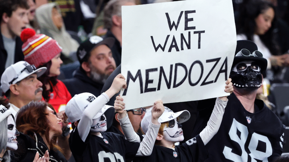 Las Vegas Raiders fans Ezra Kheel (L) and his brother Alexandros Kheel of Nevada hold up a sign referencing Indiana quarterback Fernando Mendoza, the 2025 Heisman Trophy recipient, in the second quarter of the Raiders' game against the Kansas City Chiefs at Allegiant Stadium on January 04, 2026 in Las Vegas, Nevada. The Raiders earlier clinched the No. 1 overall pick in the 2026 NFL draft. The Raiders defeated the Chiefs 14-12.
