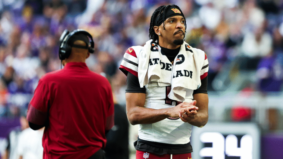 Jayden Daniels #5 of the Washington Commanders looks on from the sidelines after leaving the game during the second half against the Minnesota Vikings at U.S. Bank Stadium on December 07, 2025 in Minneapolis, Minnesota.