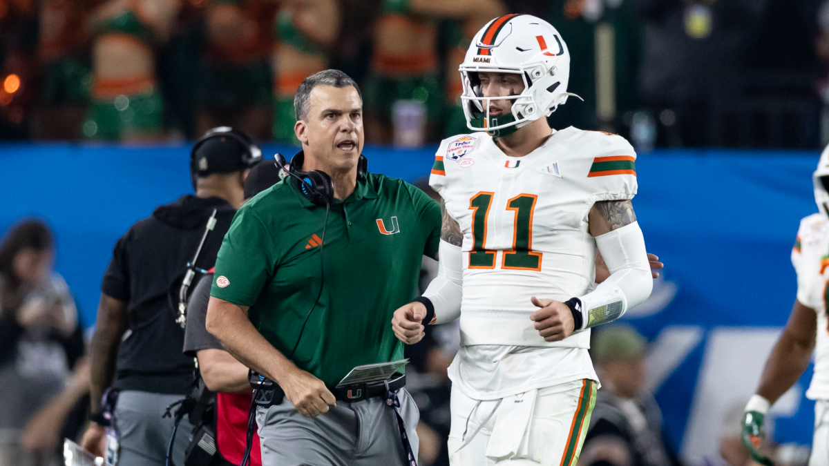Carson Beck #11 confers with Mario Cristobal of the Miami (FL) Hurricanes in the second quarter of the 2025 College Football Playoff Semifinal at State Farm Stadium on January 8, 2026 in Glendale, Arizona.