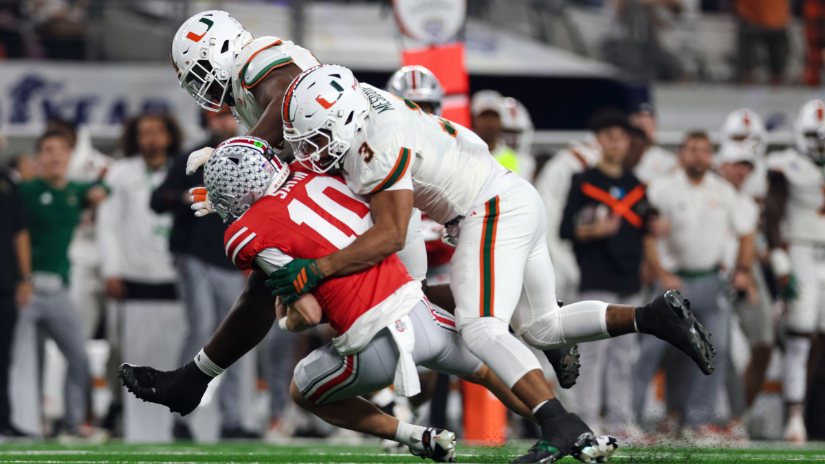 Julian Sayin #10 of the Ohio State Buckeyes is sacked by Akheem Mesidor #3 of the Miami Hurricanes during the first quarter during the College Football Playoff Quarter Final Game at AT&T Stadium on December 31, 2025 in Arlington, Texas.