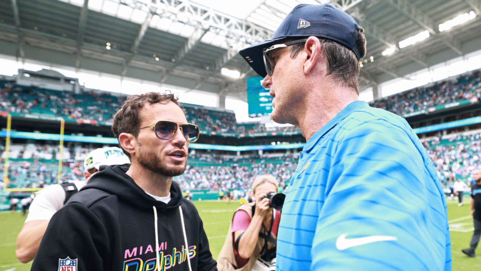 Head coach Mike McDaniel of the Miami Dolphins and head coach Jim Harbaugh of the Los Angeles Chargers talk after the game at Hard Rock Stadium on October 12, 2025 in Miami Gardens, Florida.