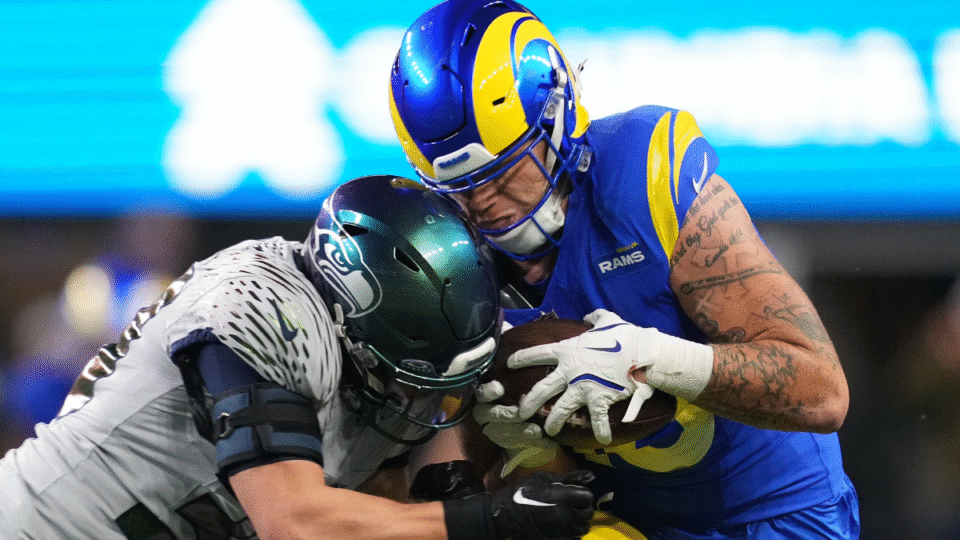 Josaiah Stewart #10 of the Los Angeles Rams is hit by Ty Okada #39 of the Seattle Seahawks during the fourth quarter at Lumen Field on December 18, 2025 in Seattle, Washington.