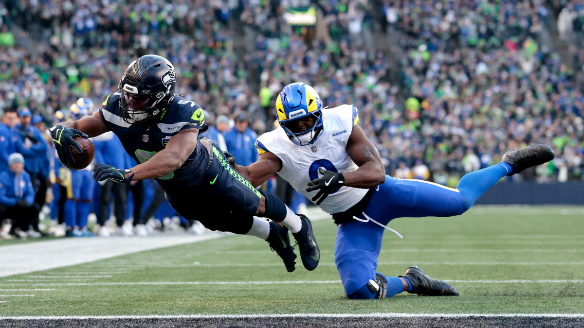 Kenneth Walker III #9 of the Seattle Seahawks scores a first quarter touchdown in front of Byron Young #0 of the Los Angeles Rams in the NFC Championship game at Lumen Field on January 25, 2026 in Seattle, Washington.