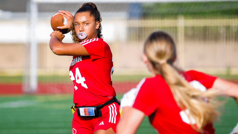 Makena Cook, left, of Orange Lutheran throws passes during a pre-game warmup for a girls flag football scrimmage game against Marina at Marina High School in Huntington Beach on Wednesday, August 9, 2023. Girls flag football is an official CIF sport this coming school year.