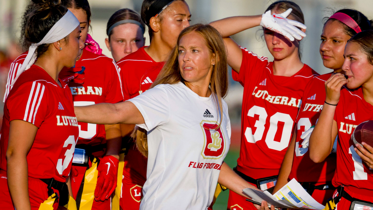 Orange Lutheran coach Kristen Sherman, center, huddles up her team during a girls flag football scrimmage game against Marina at Marina High School in Huntington Beach on Wednesday, August 9, 2023. Girls flag football is an official CIF sport this coming school year.