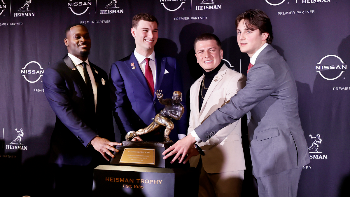 Heisman Trophy candidates Jeremiyah Love of the Notre Dame Fighting Irish, left, Fernando Mendoza of the Indiana Hoosiers, Diego Pavia of the Vanderbilt Commodores and Julian Sayin of the Ohio State Buckeyes touch the Heisman trophy during a press conference before the 2025 Heisman Trophy Presentation at the Marriott Marquis Hotel on December 13, 2025 in New York City.