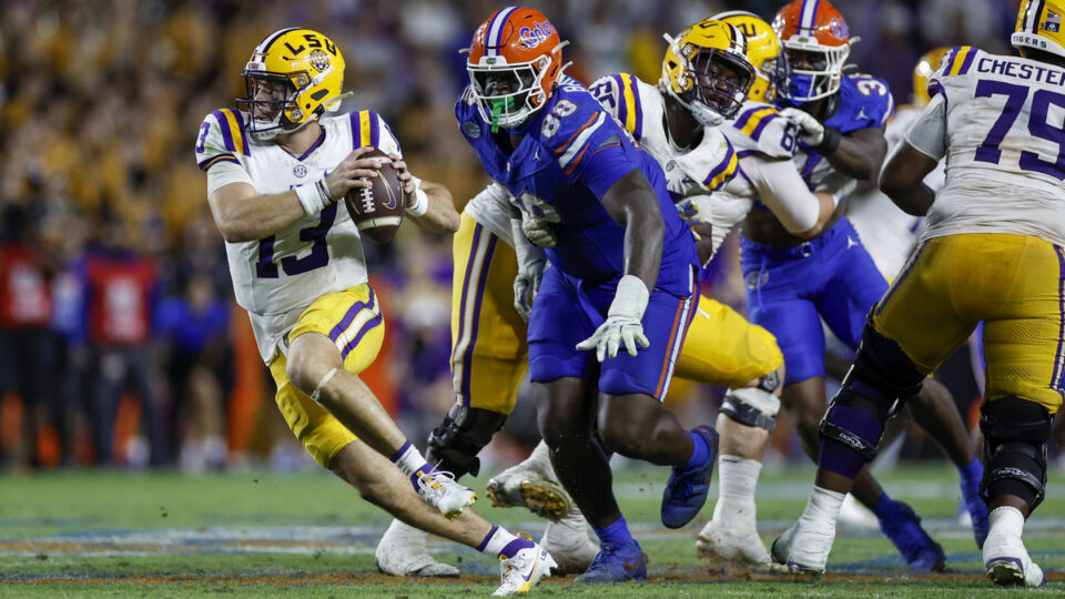LSU Tigers quarterback Garrett Nussmeier (13) scrambles from Florida Gators defensive lineman Caleb Banks (88) during the game between the LSU Tigers and the Florida Gators on November 16, 2024 at Ben Hill Griffin Stadium at Florida Field in Gainesville, Fl.