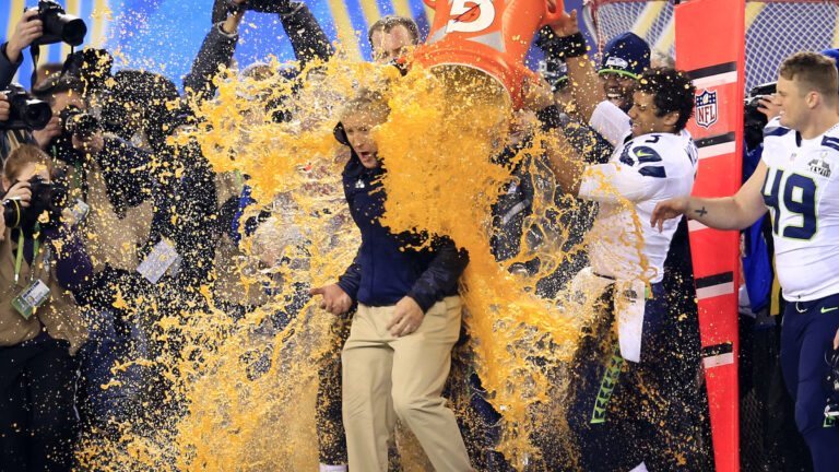 Tight end Zach Miller #86 and quarterback Russell Wilson #3 of the Seattle Seahawks dump Gatorade on head coach Pete Carroll in the fourth quarter of Super Bowl XLVIII against the Denver Broncos at MetLife Stadium on February 2, 2014 in East Rutherford, New Jersey. The Seattle Seahawks won 43-8.