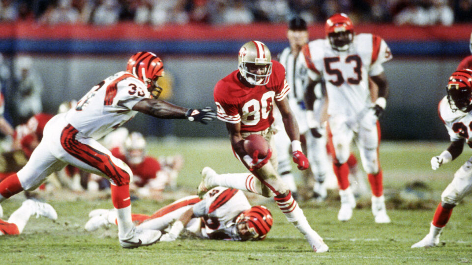 Jerry Rice #80 of the San Francisco 49ers runs with the ball while being pursued by David Fulcher #33 of the Cincinnati Bengals during Super Bowl XXIII on January 22, 1989 at Joe Robbie Stadium in Miami, Florida. The 49ers won the Super Bowl 20-16.