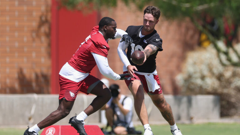 TEMPE, ARIZONA - MAY 08: Carson Beck #19 of the Arizona Cardinals hands off the ball to Jeremiyah Love #4 during a team rookie mincamp at Dignity Health Arizona Cardinals Training Center on May 08, 2026 in Tempe, Arizona.
