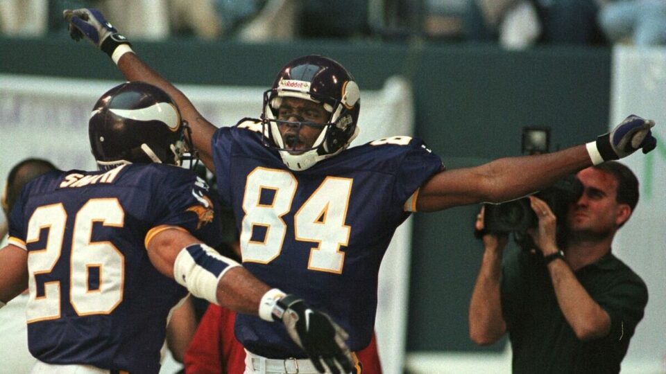 Minnesota Vikings receiver Randy Moss (C) celebrates his 51 yard touchdown reception on the fourth play of the game versus the Dallas Cowboys at Texas Stadium in Irving, TX, 26 November. At left is teammate Robert Smith.