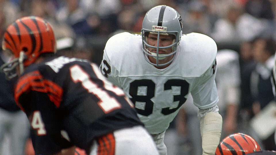 Linebacker Ted Hendricks #83 of the Los Angeles Raiders looks across the line of scrimmage at quarterback Ken Anderson #14 of the Cincinnati Bengals during a game at Riverfront Stadium on November 28, 1982 in Cincinnati, Ohio. The Bengals defeated the Raiders 31-17.