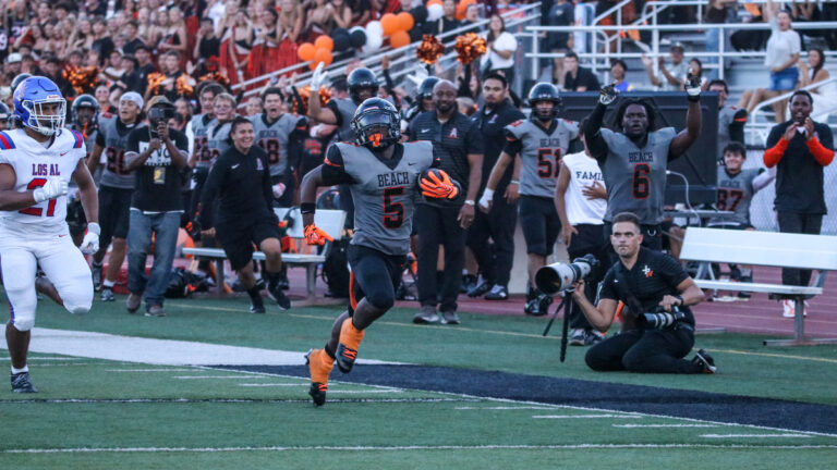 Huntington Beach running back Dallas Miller runs the ball in the first quarter of a matchup between Huntington Beach and Los Alamitos on August 27, 2026 at Cap Sheue Field in Huntington Beach, California.