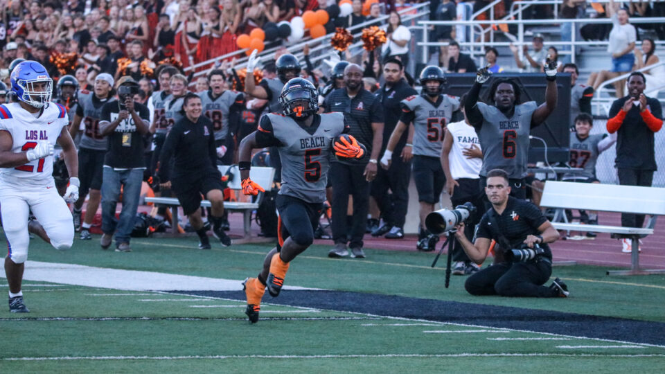 Huntington Beach running back Dallas Miller runs the ball in the first quarter of a matchup between Huntington Beach and Los Alamitos on August 27, 2026 at Cap Sheue Field in Huntington Beach, California.
